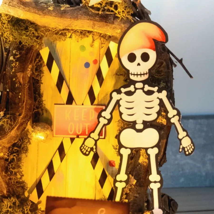 Wichteltür im Halloween-Look mit Absperrband, Schild Keep out und einem Skelett mit Wichtelmütze